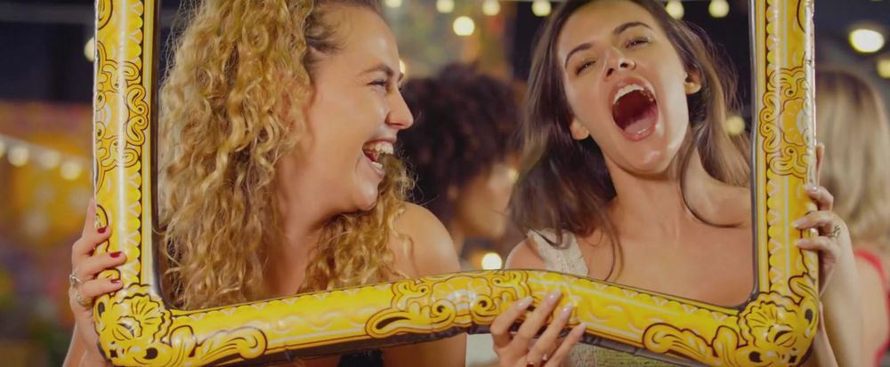 Photo Booth in O'Fallon, Missouri with people laughing and celebrating through ornate gold picture frames at a party. Laugh Out Loud Smiles.