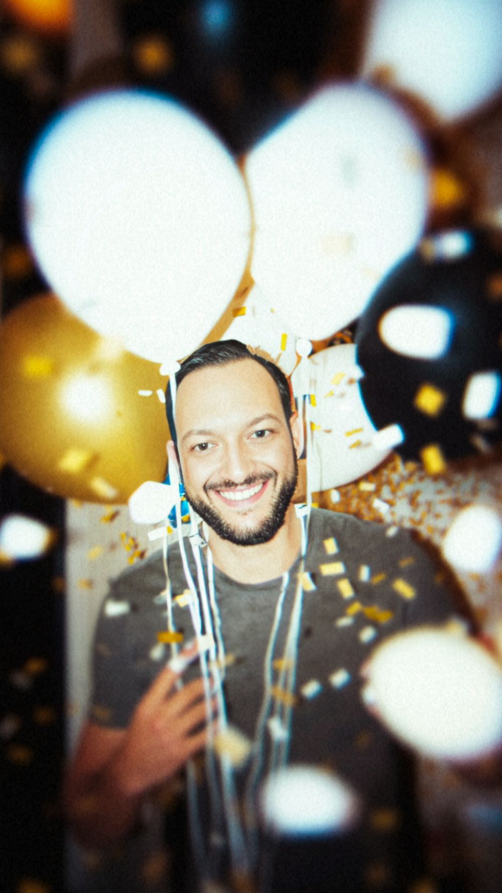 O'Fallon, Missouri photographer in celebratory scene with bokeh lights and confetti in warm tones.