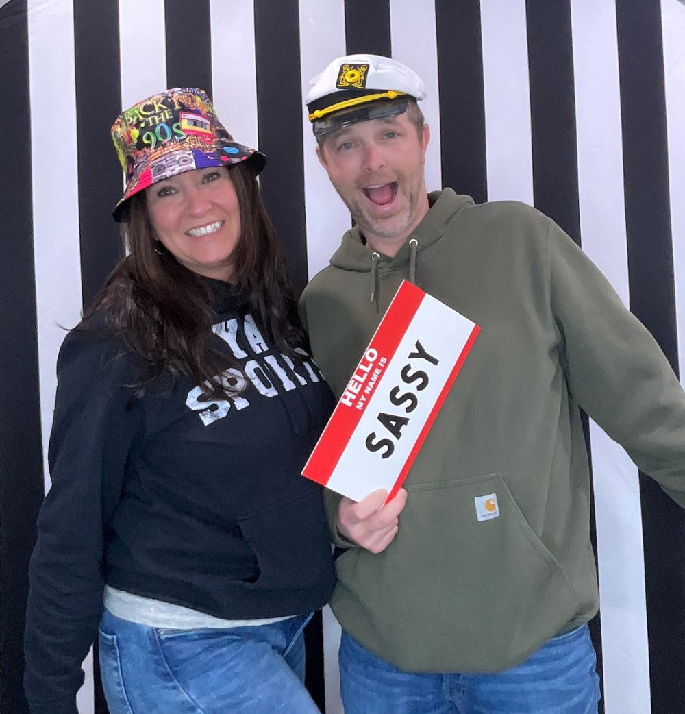 Photo Booth party rental in O'Fallon, Missouri with people posing together against a black and white striped background. Photo Booth rentals