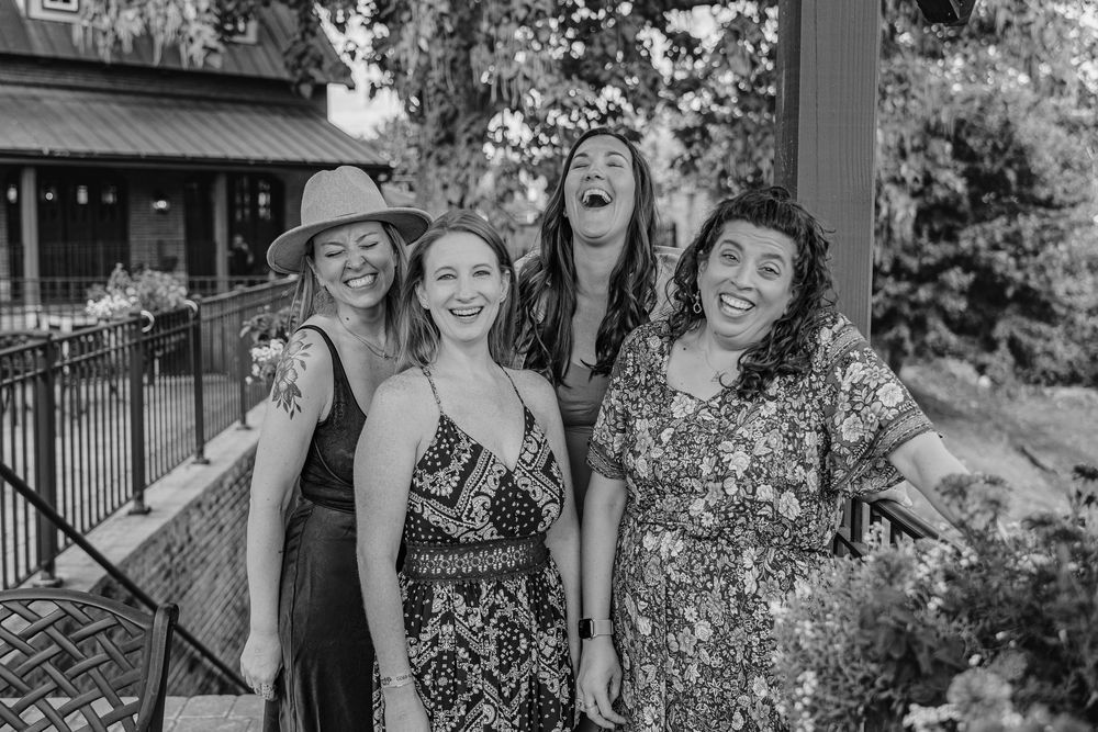 Friend's engagement party photo session in Black and white photo of four friends laughing together outdoors in summer dresses in Herman, MO.