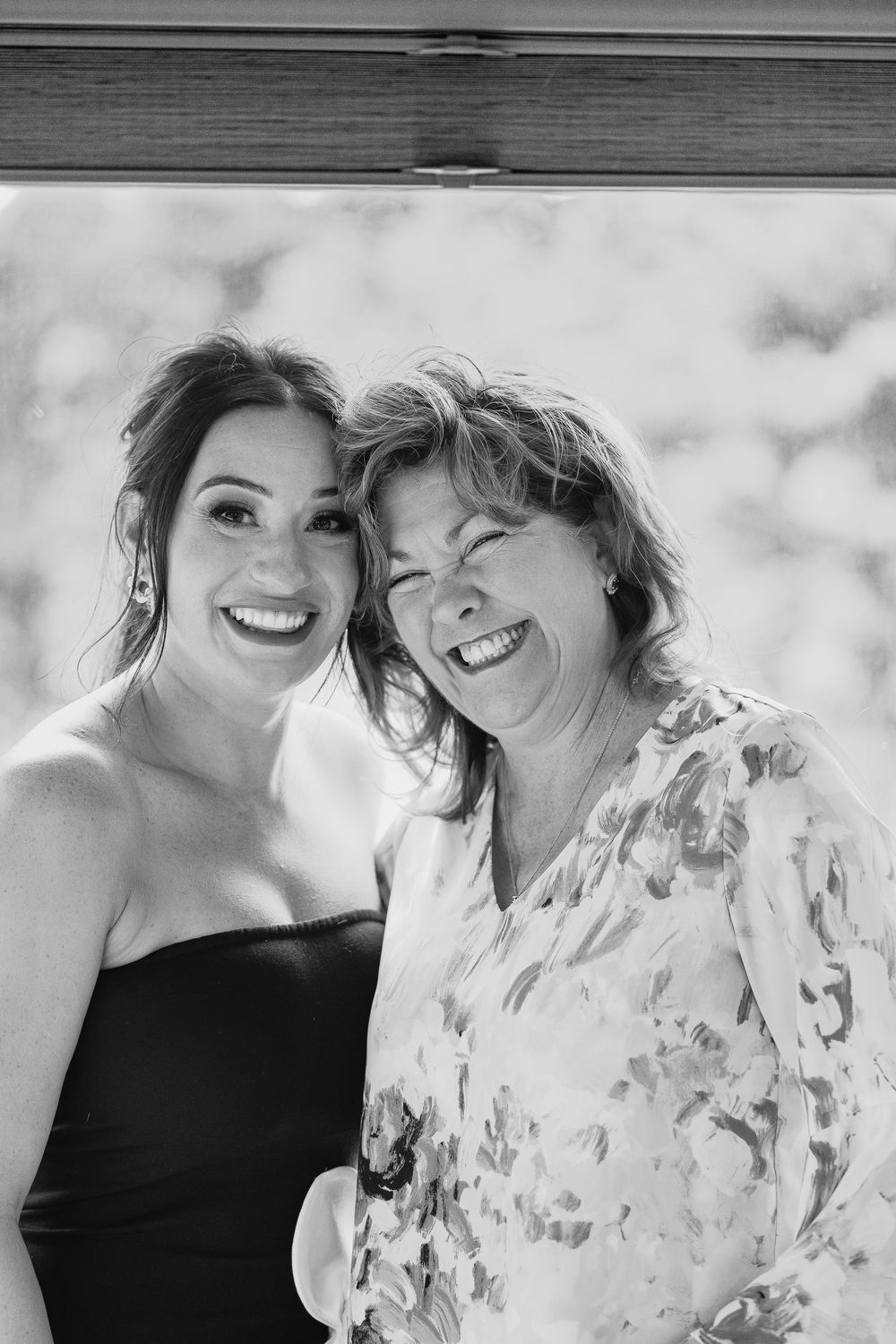Lifestyle photography in O'Fallon, Missouri of a black and white portrait of two people sharing a joyful moment together in casual attire.