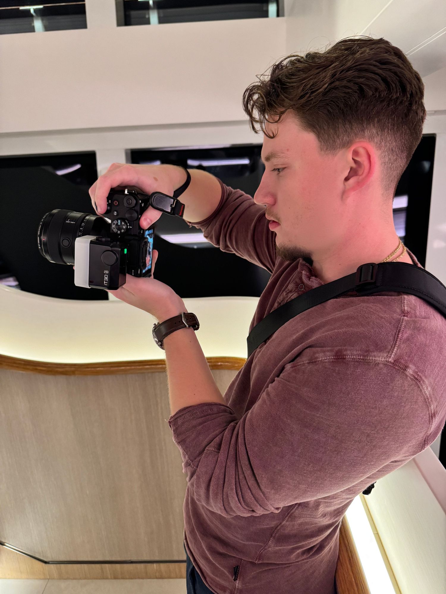 Photographer using professional camera equipment in indoor studio setting.