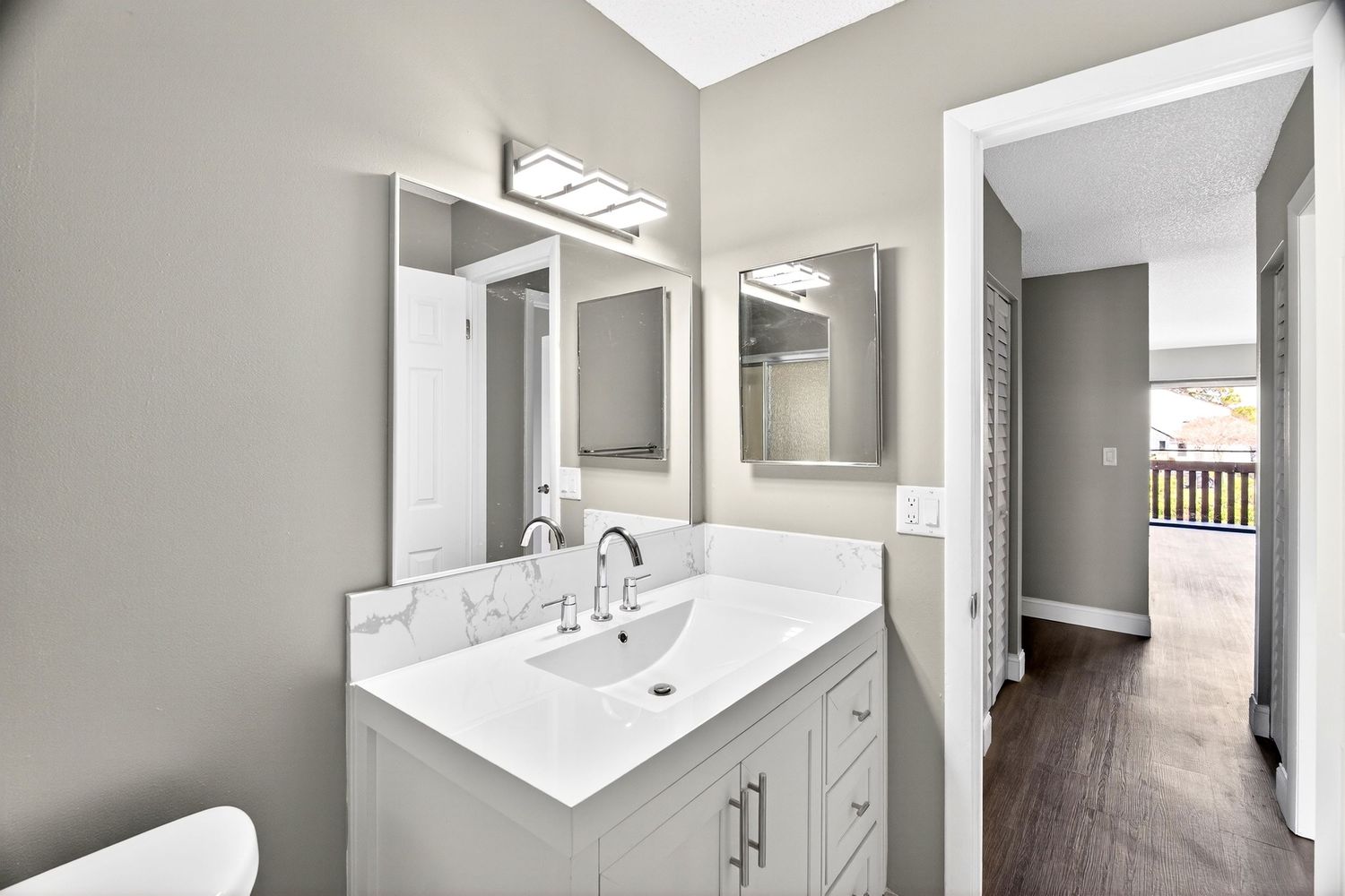 Modern bathroom renovation featuring white vanity, gray walls, and contemporary fixtures in a bright, clean space.