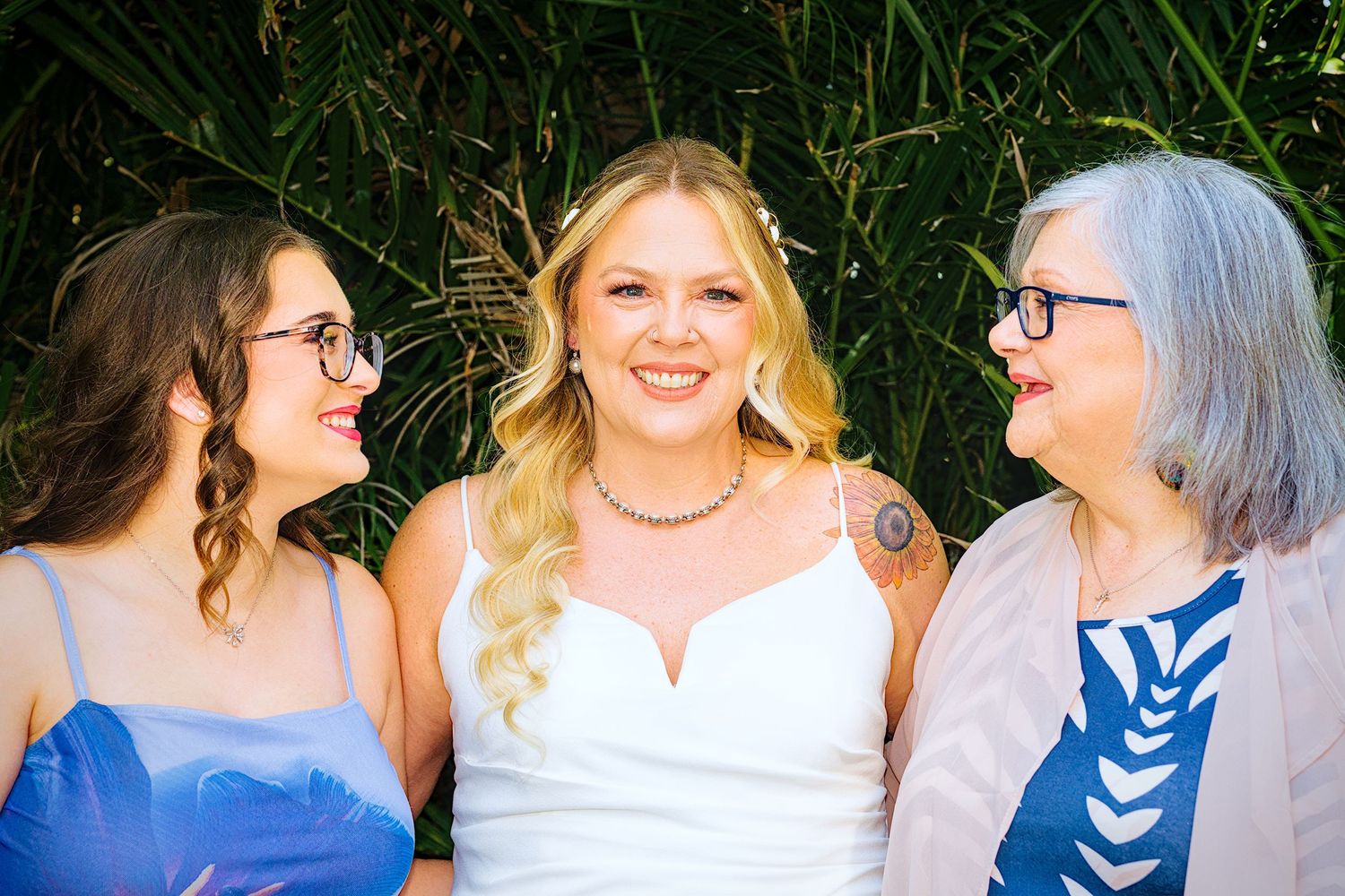 Group of women in coordinating blue and white outfits laughing together outdoors.