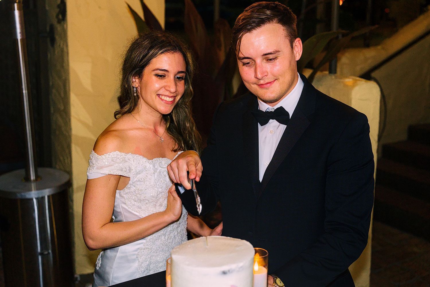 Candlelit wedding reception with couple sharing intimate moments.