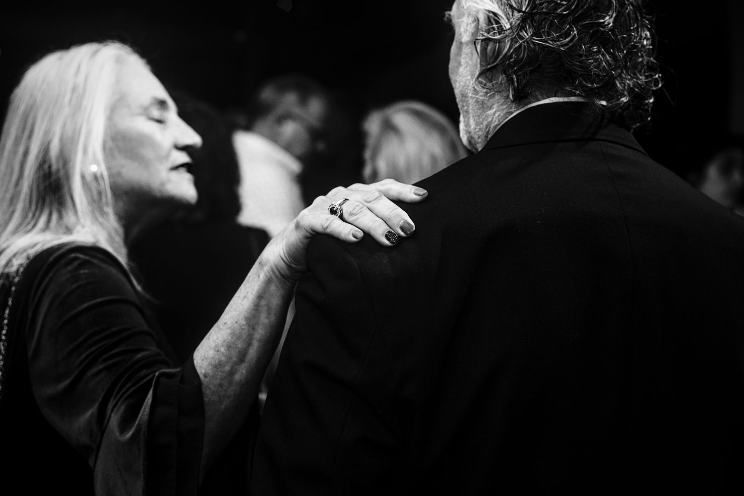 Black and white portrait of newlyweds dancing together at their reception.