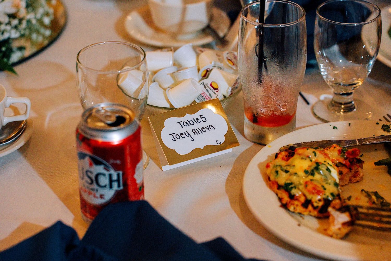 Wedding reception table setting with Busch beer can, sugar cubes, and a personalized place card.