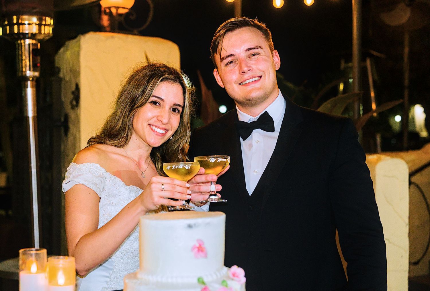 Wedding couple sharing drinks during their evening reception celebration.