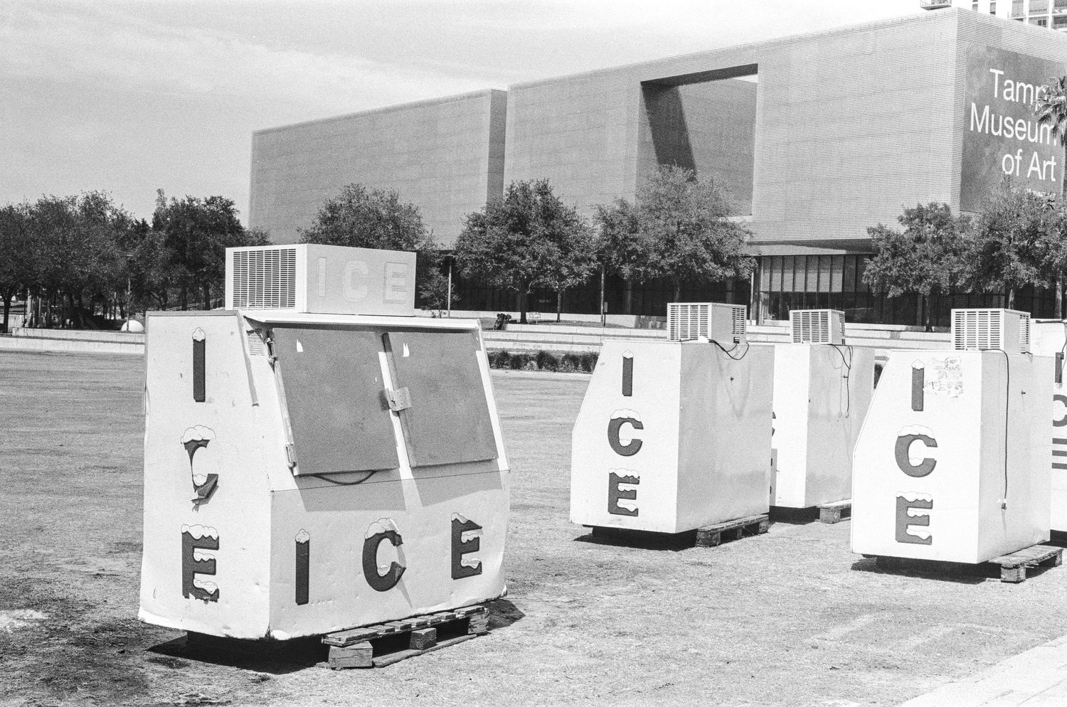 Black and white photo of ice vending machines outside the Tampa Museum of Art on a sunny day.