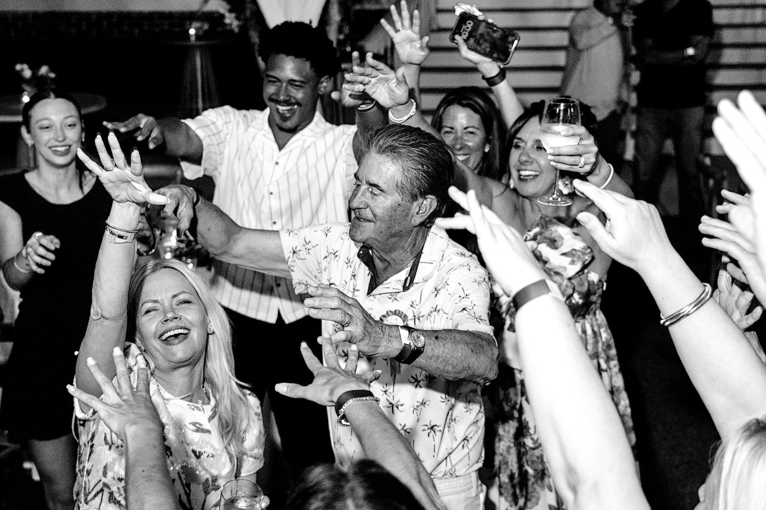Diverse group of adults laughing and dancing together at a lively celebration party.