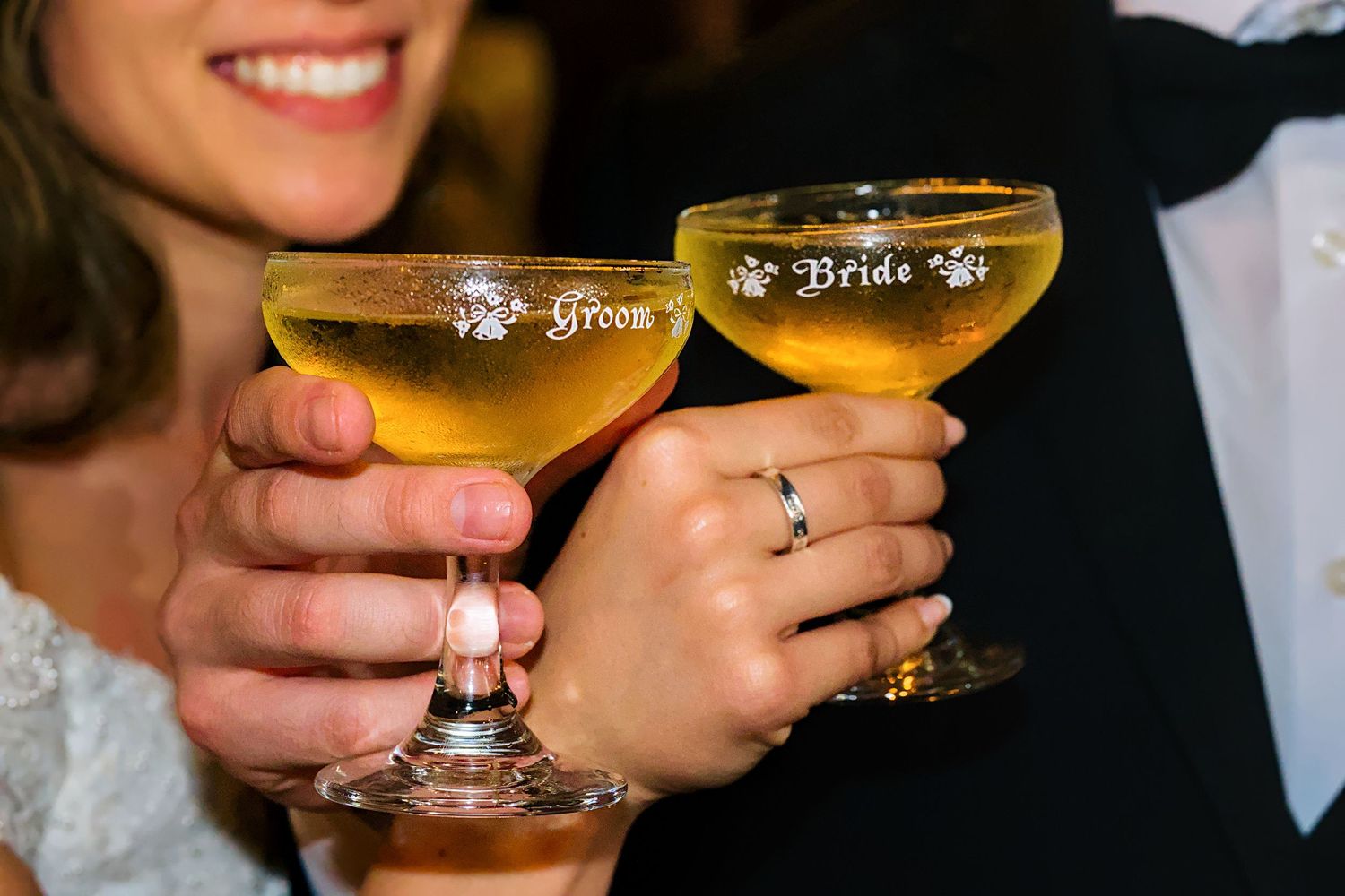 Close-up of champagne glasses being held during wedding toasts.