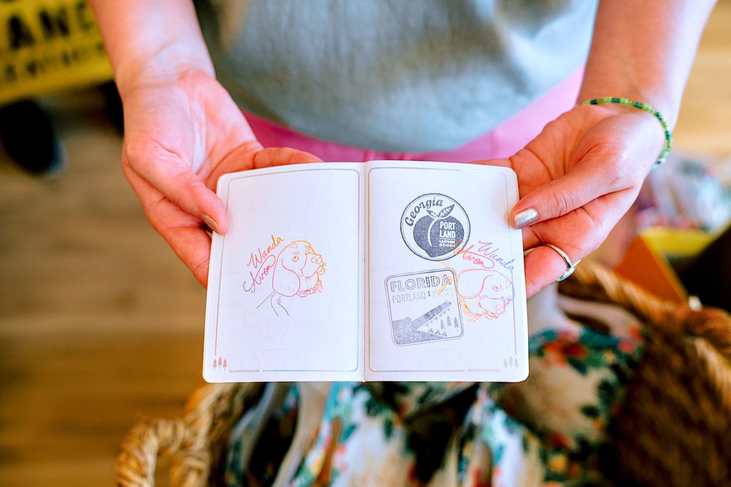 Hands holding an open passport booklet with colorful travel stamps and signatures, including a Florida stamp.