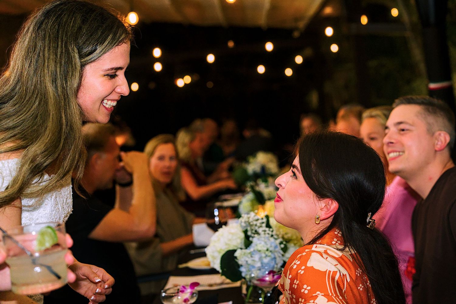Wedding guests enjoying a lively celebration under twinkling lights.