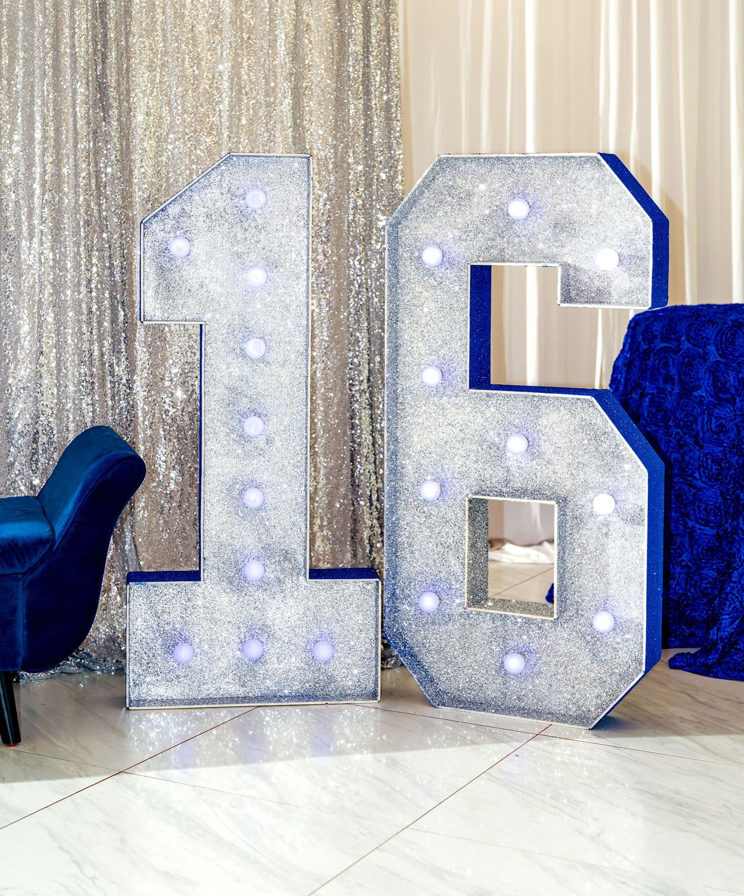 Glittery marquee number 16 with LED lights in silver and blue for a sweet sixteen birthday party.