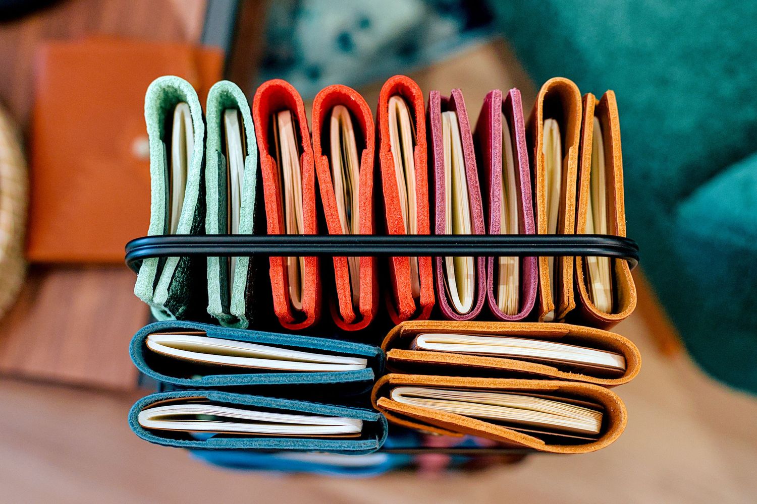 Colorful leather wallets stacked together displaying vibrant hues of green, orange, red, blue, and yellow.