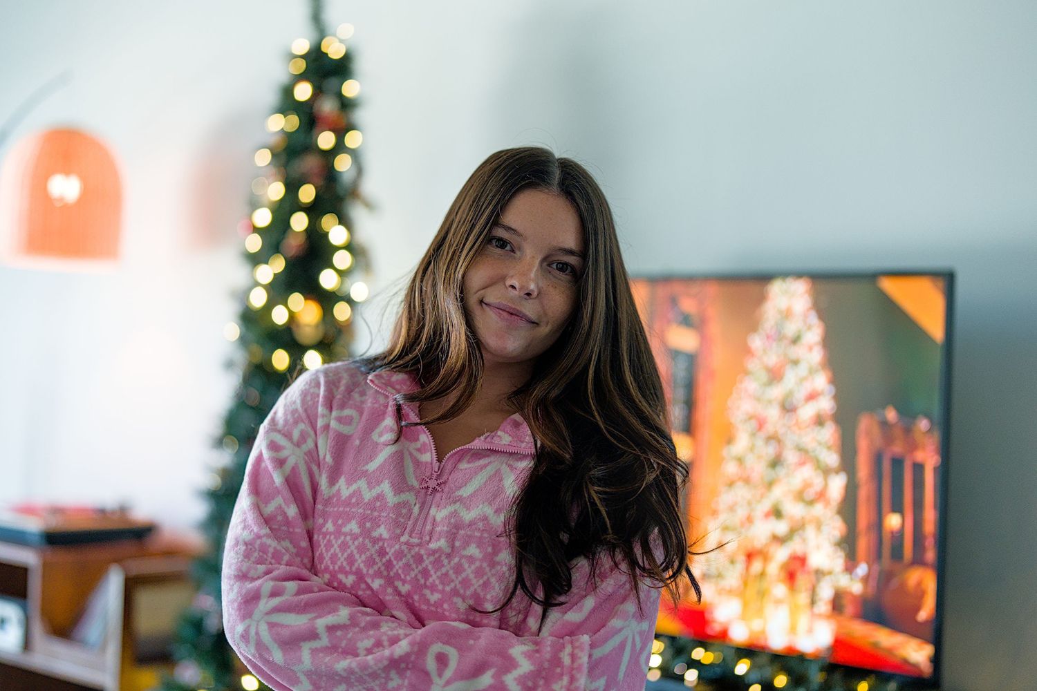 A cozy Christmas scene with decorated trees glowing in the background and festive holiday decor.