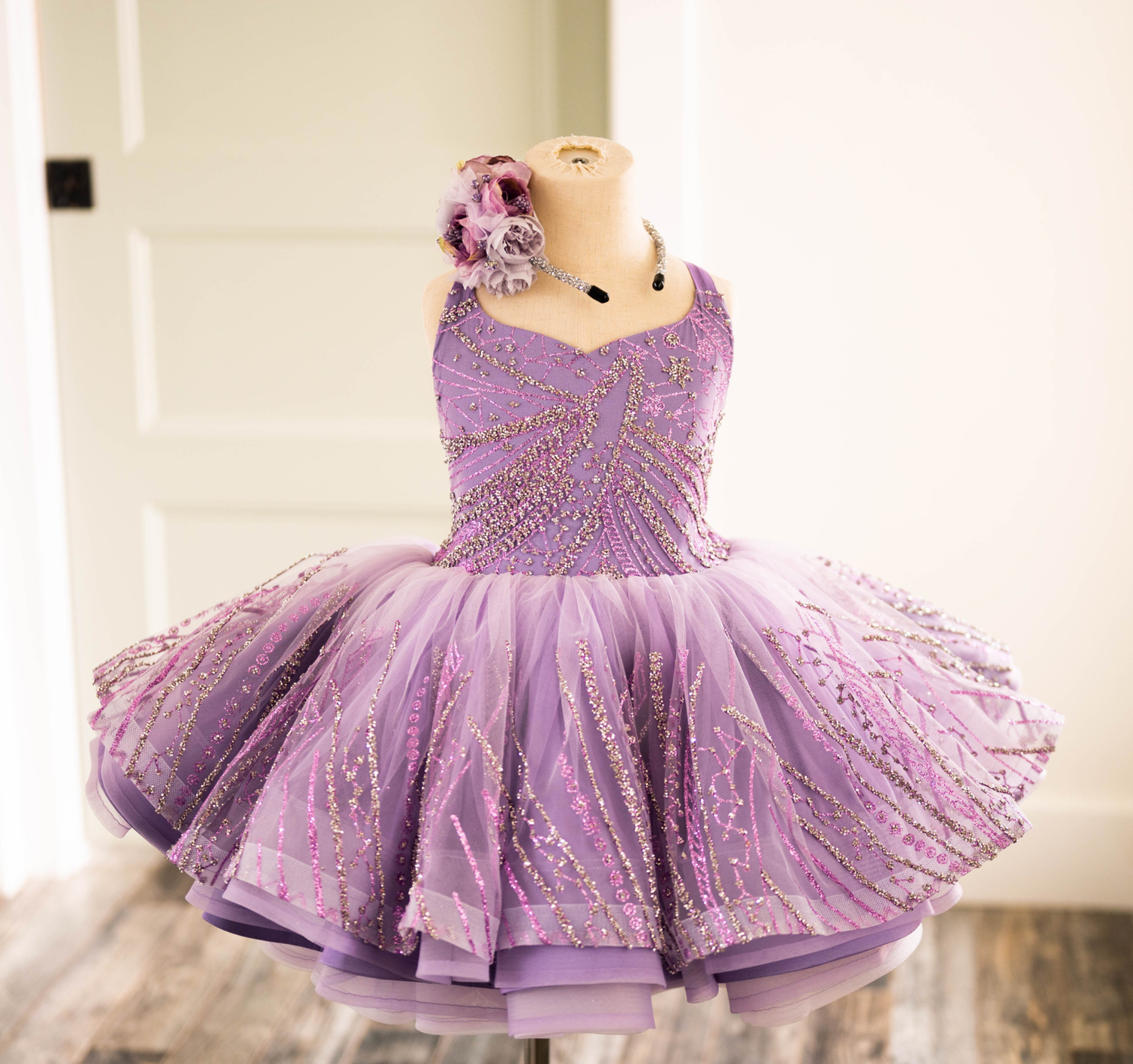 Lavender tulle party dress with sparkly bodice and ruffled skirt on display.