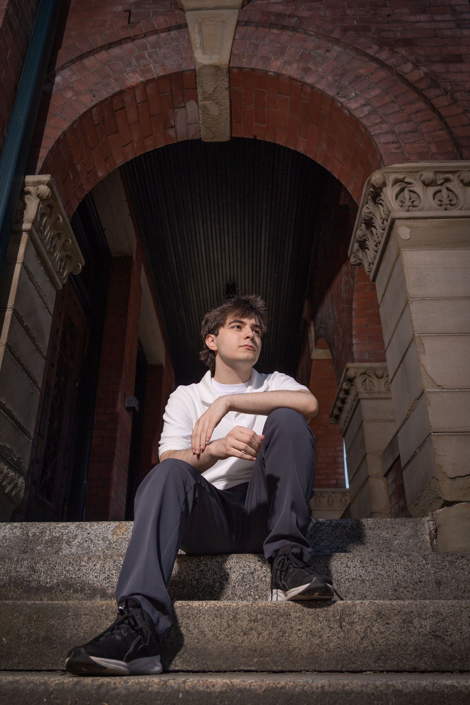 Artistic portrait series under brick archways with dramatic lighting and shadows.
