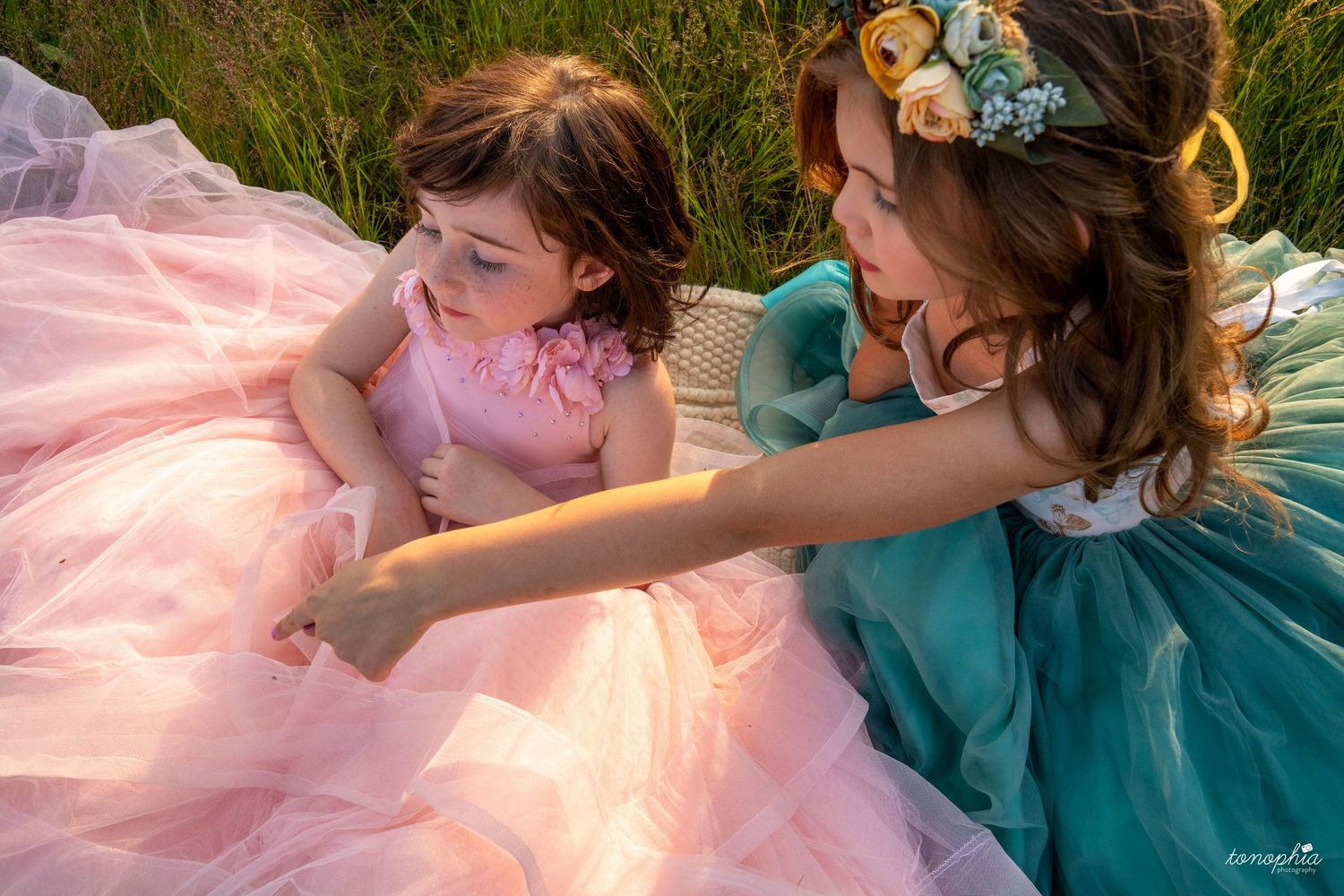 Dreamy portrait session featuring turquoise and pink princess dresses in a golden field.