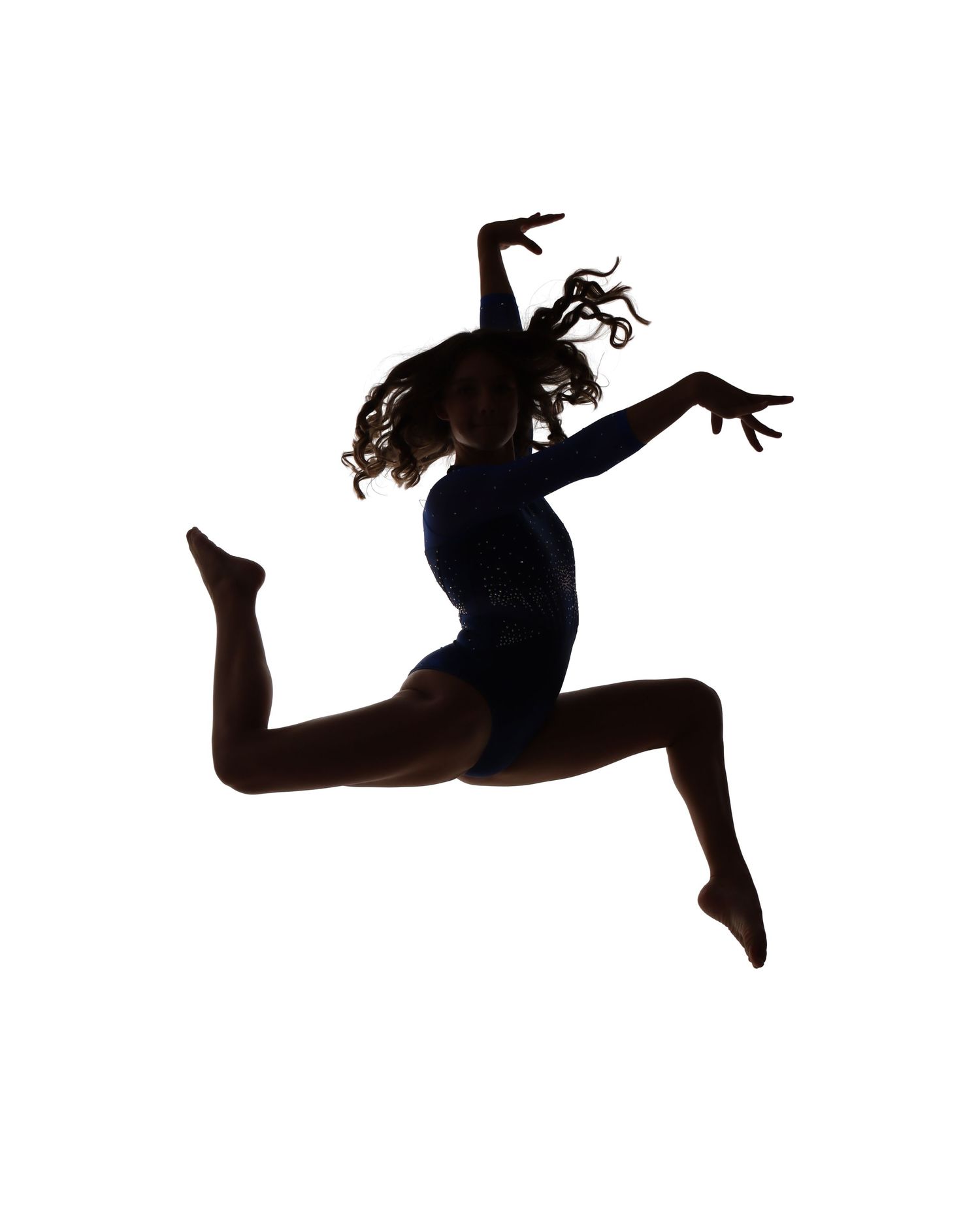 Silhouette of dancer in mid-leap against white background showing graceful form.