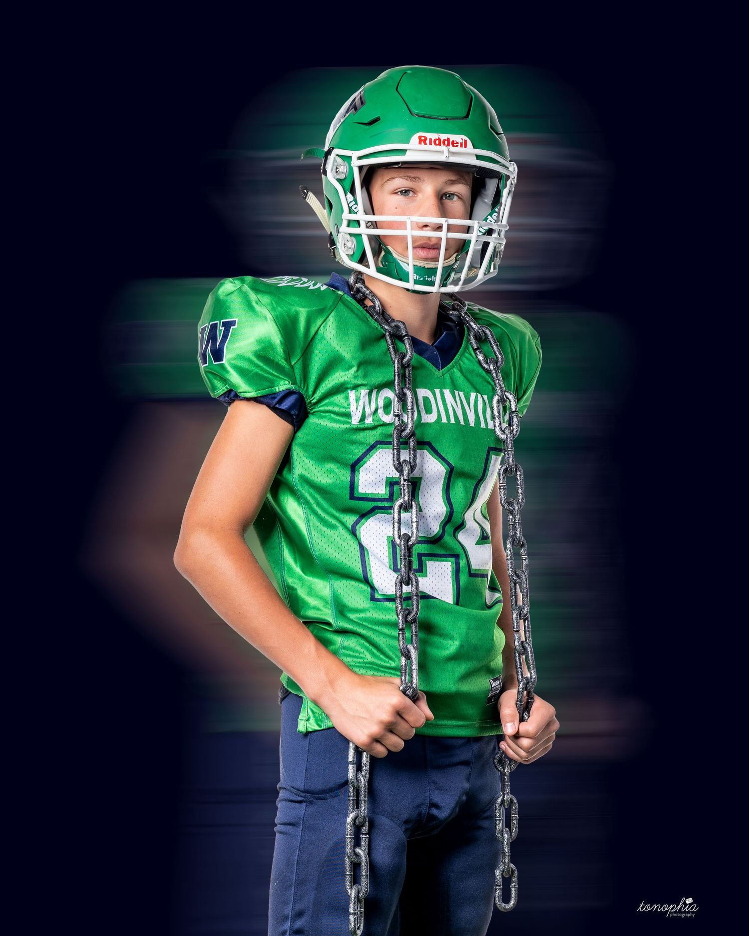 Youth football player in bright green jersey and helmet poses dramatically against dark background with motion effects.