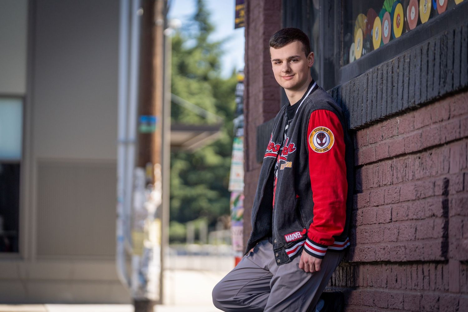 Athletic style portraits taken against brick architecture with varsity jacket styling.
