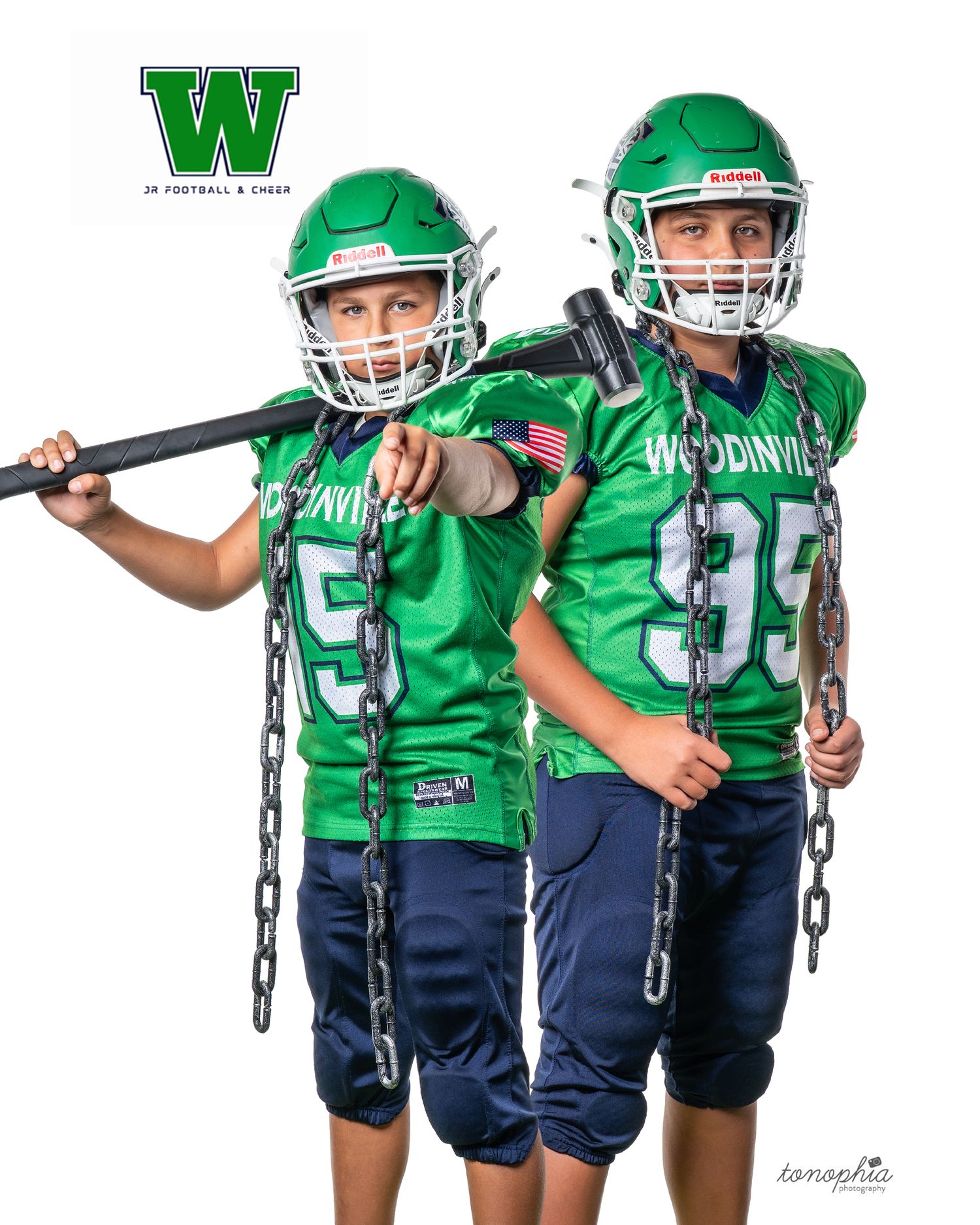 Youth football players in green and navy uniforms posing with chains for team photo.