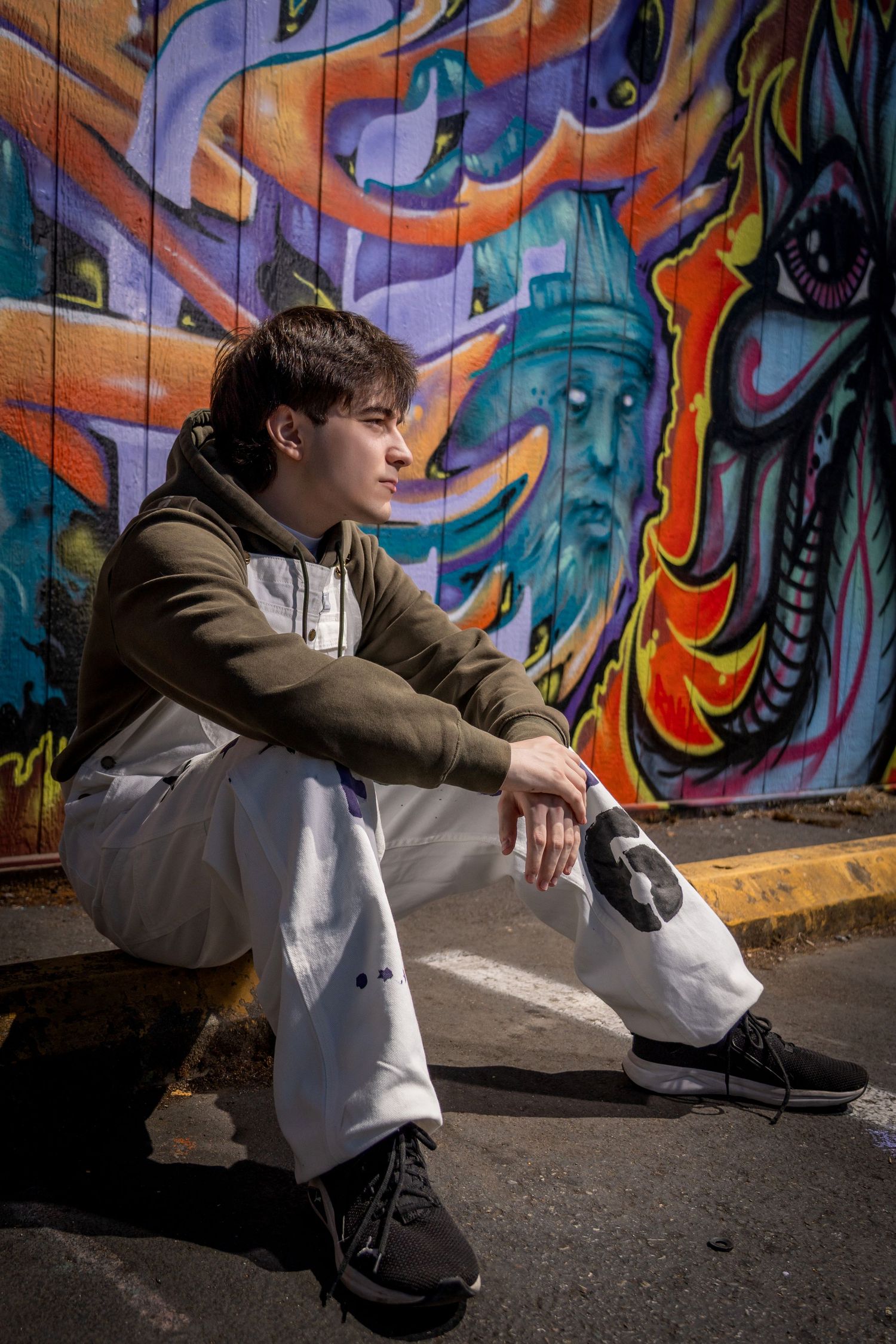 Urban photography session featuring casual poses against colorful street art backdrop.
