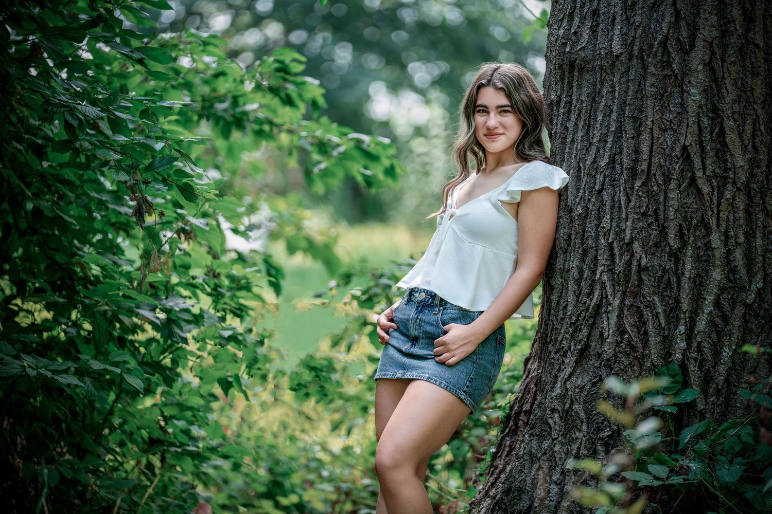 Artistic nature photography series showing poses against trees in a lush green forest setting.