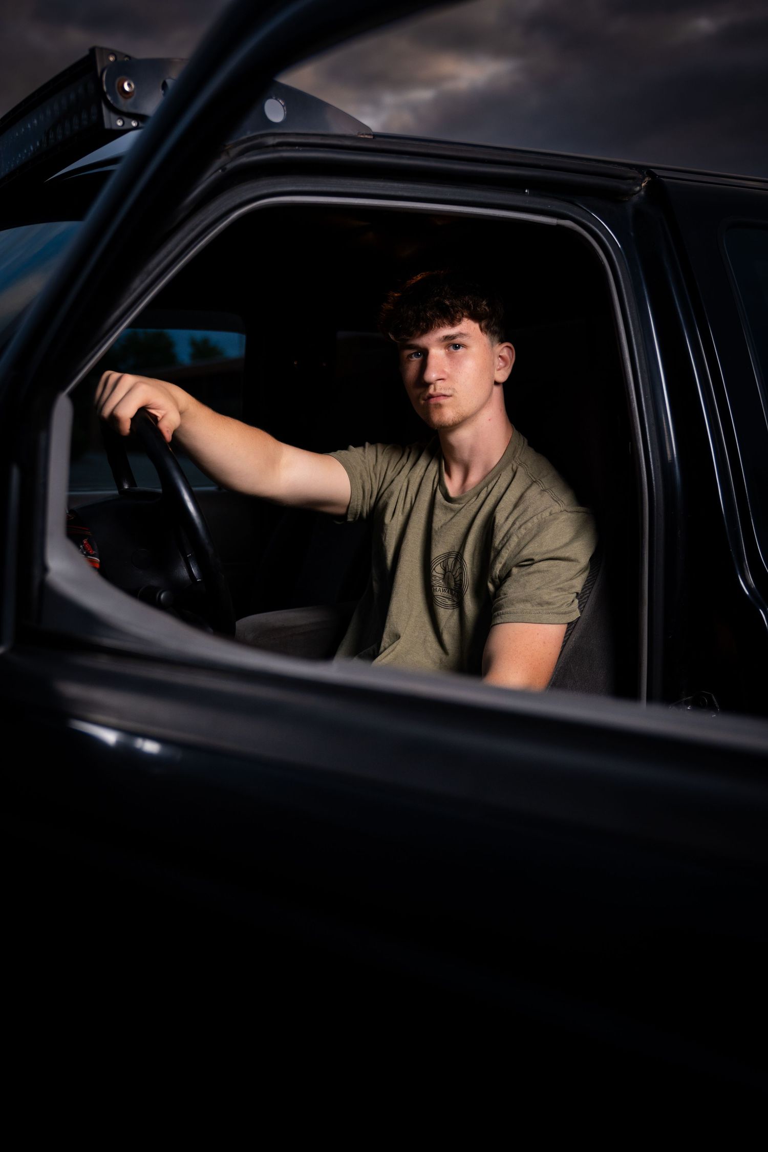 Moody portraits taken through car window at dusk.