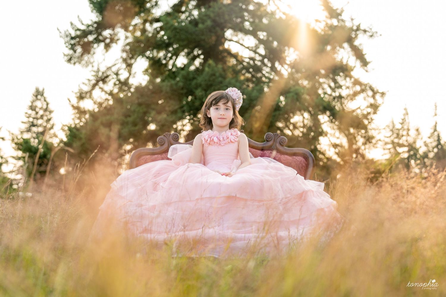 Enchanting sunset photoshoot with pink princess gown in tall grass.