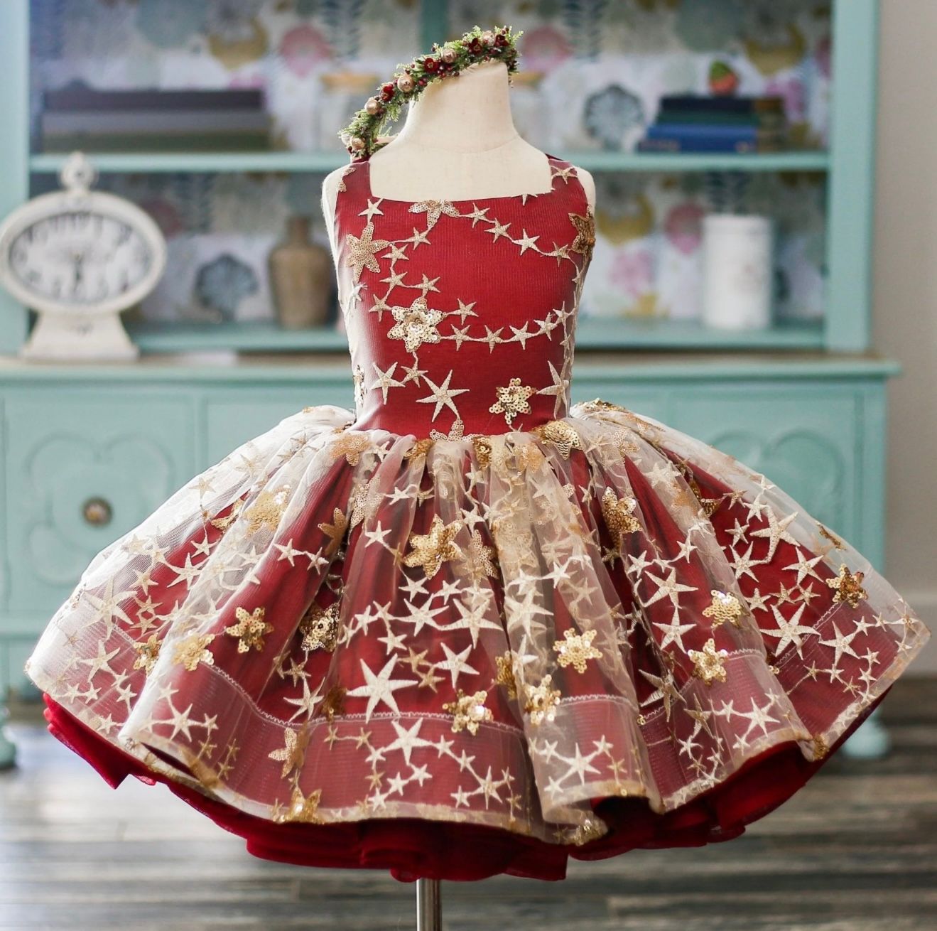 Red and gold star-patterned tutu dress displayed on mannequin with layered ruffles.