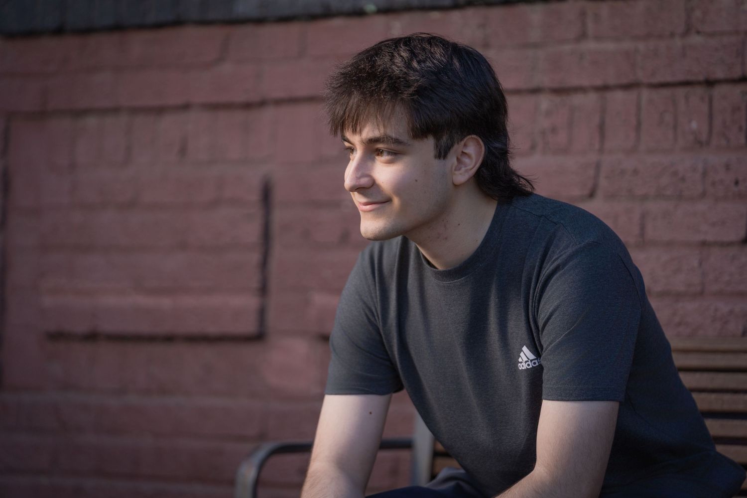 Urban portrait series against red brick wall showing casual poses and natural lighting.