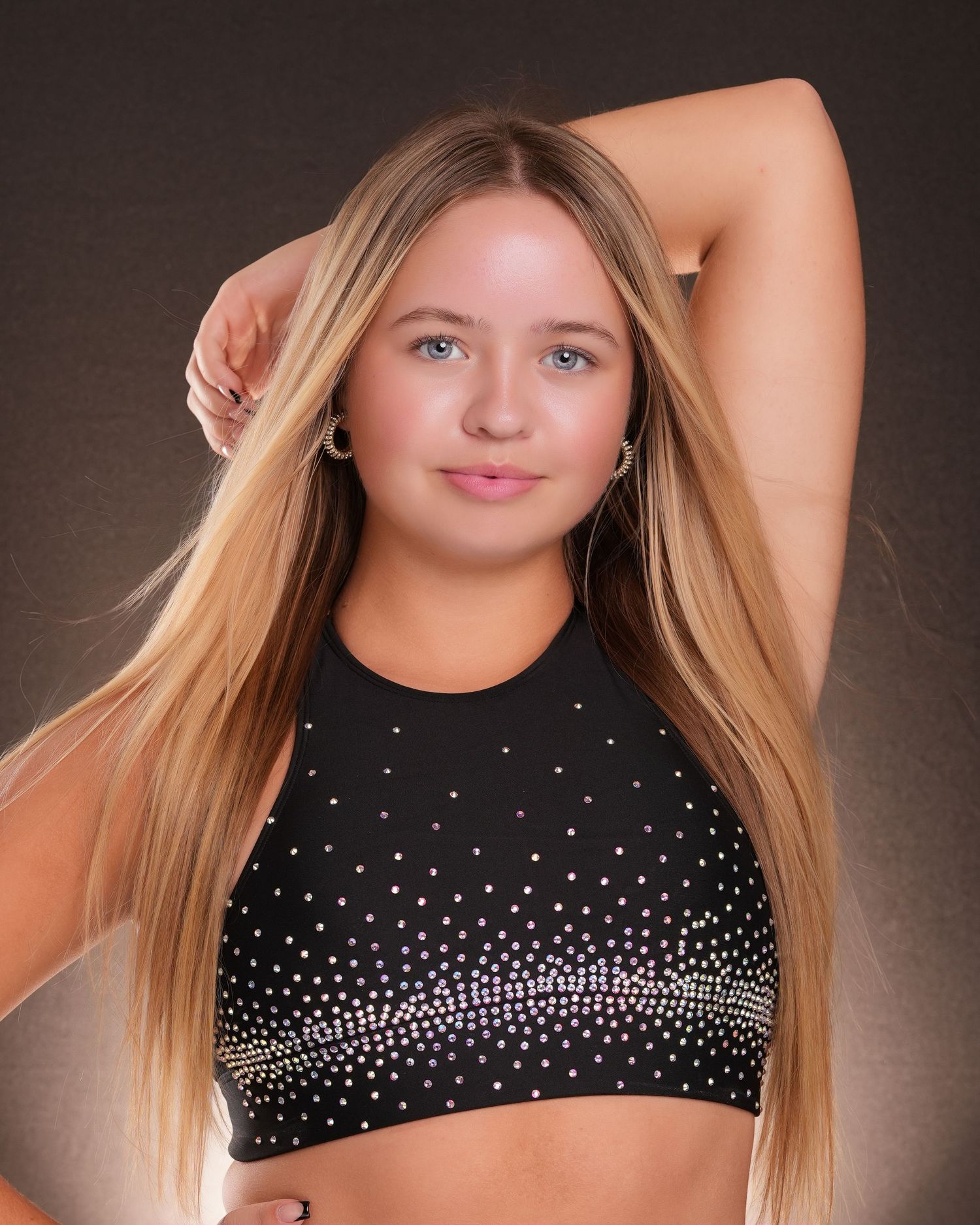 Dance portrait featuring black sparkly costume top and graceful pose.