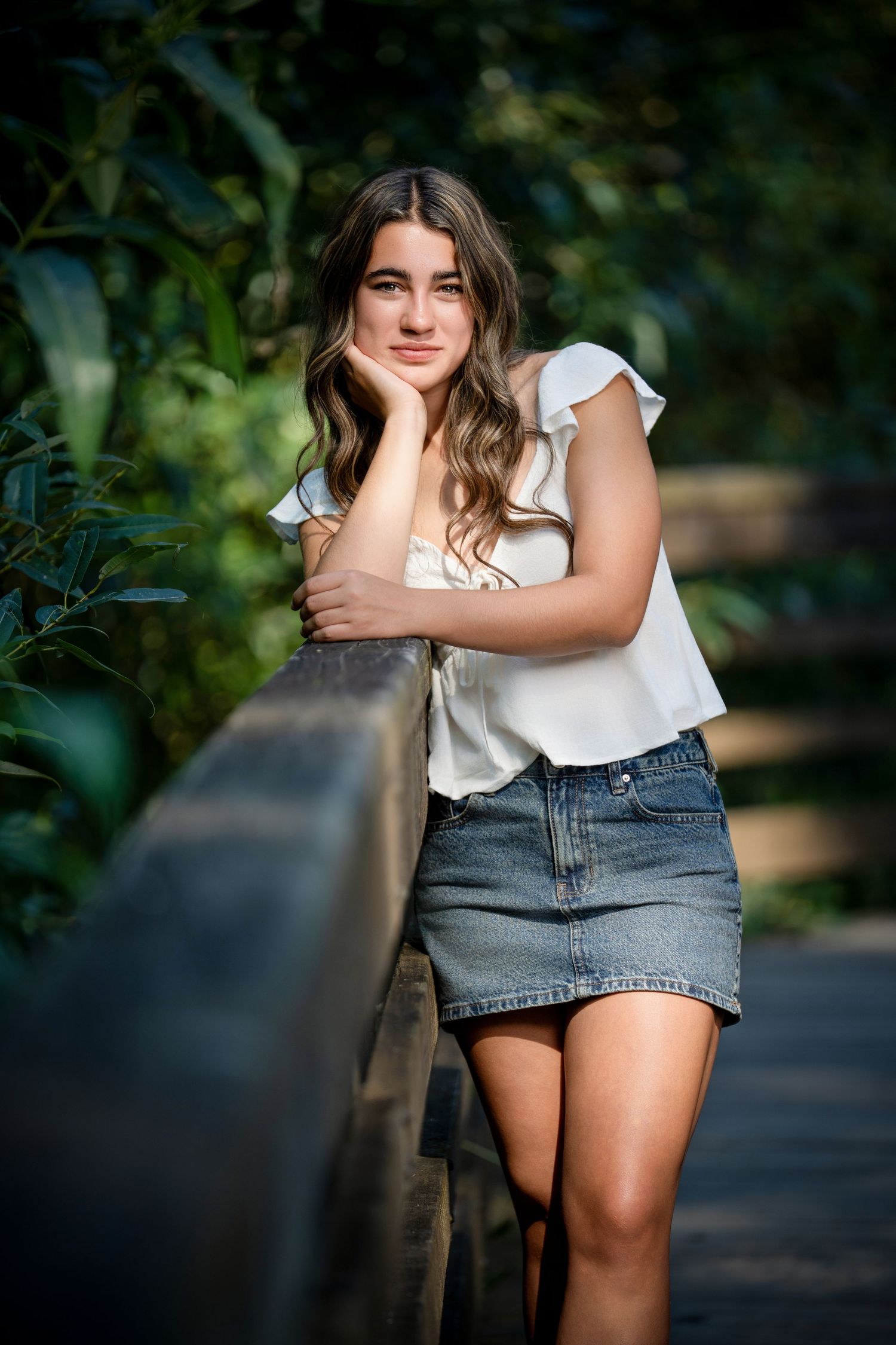 Casual summer outfit with white top and denim shorts in outdoor setting.
