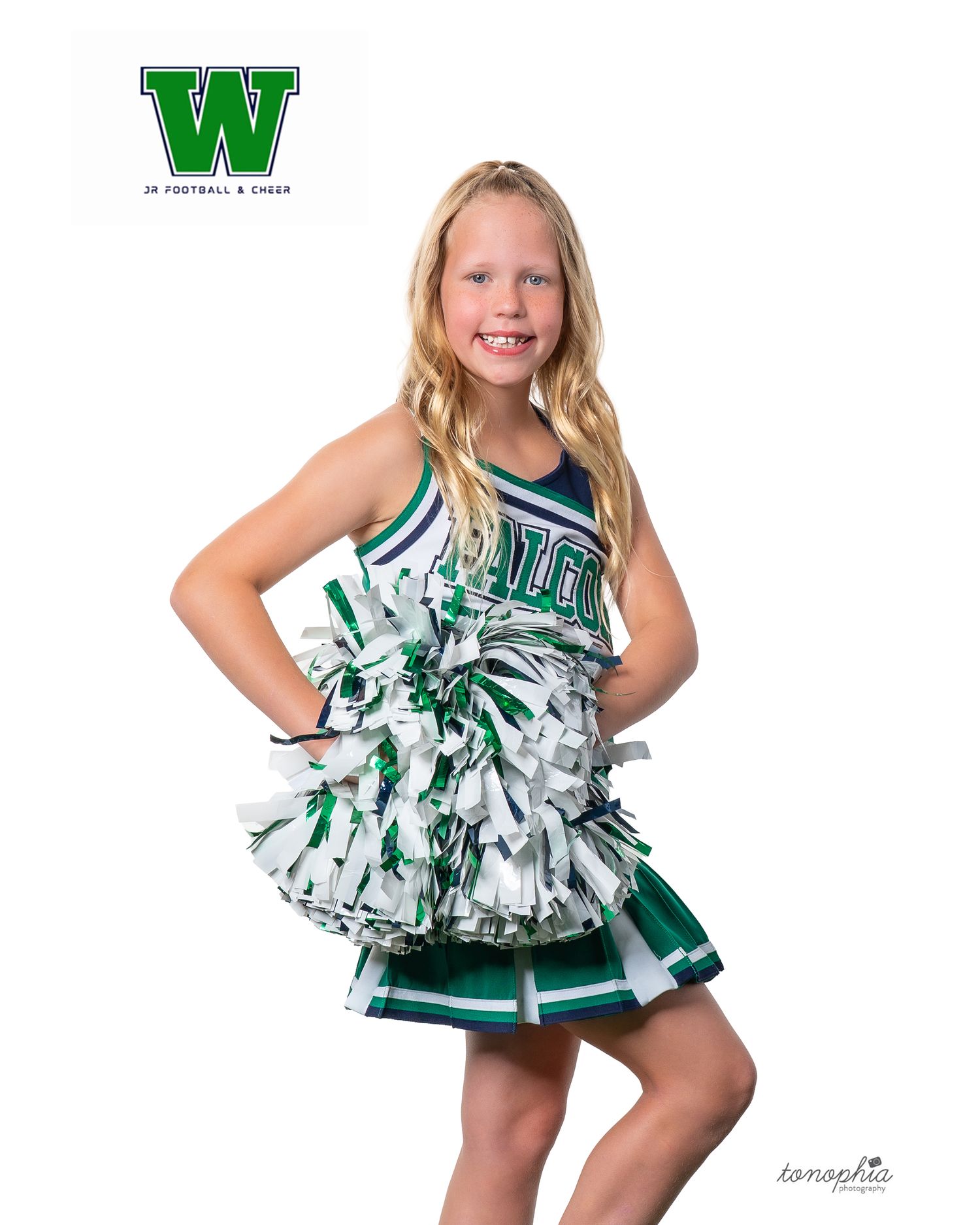Youth cheerleader poses in green and white uniform with pom poms and team logo.