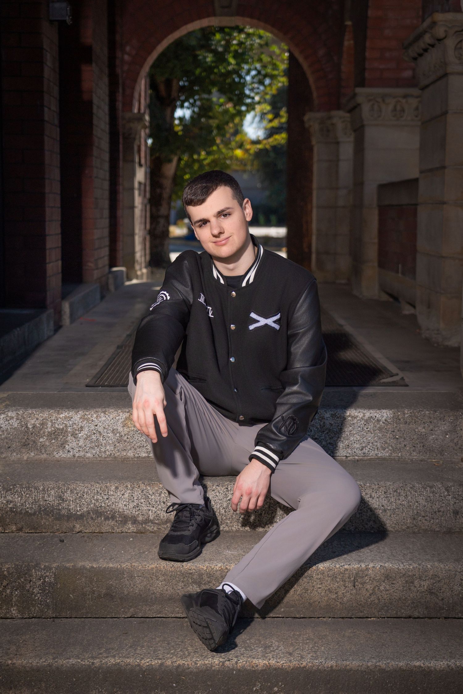 Urban fashion portraits on concrete steps with architectural elements.