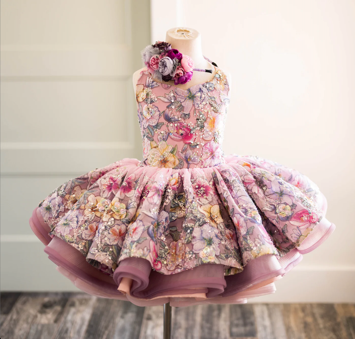 Romantic floral print tutu dress in pink with layered ruffles displayed on mannequin.