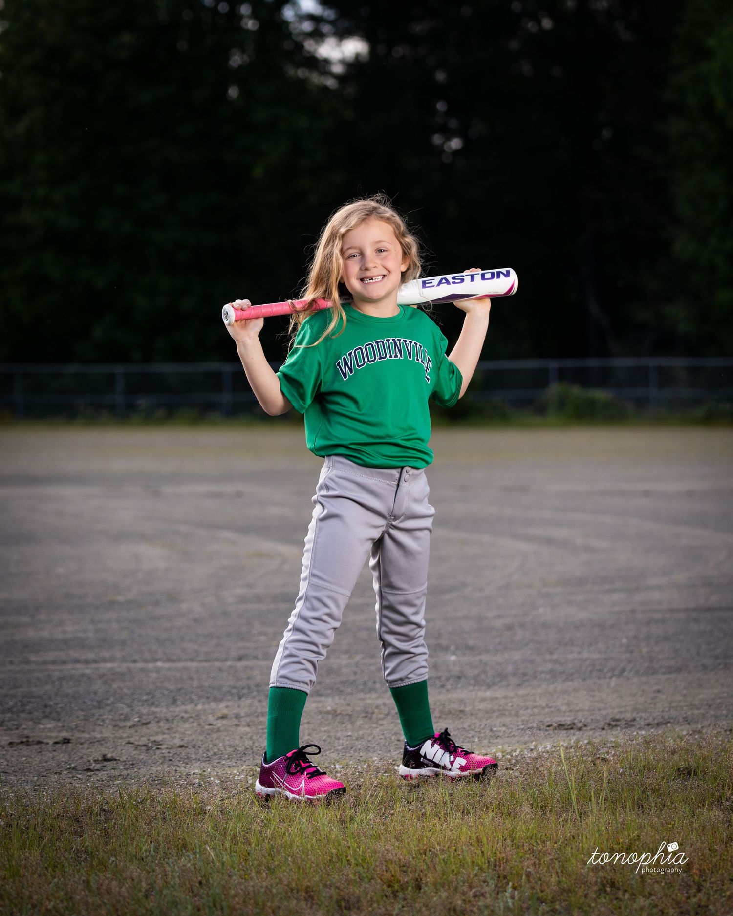 Progressive sequence of a small child in green shirt and gray pants playing outdoors on asphalt.