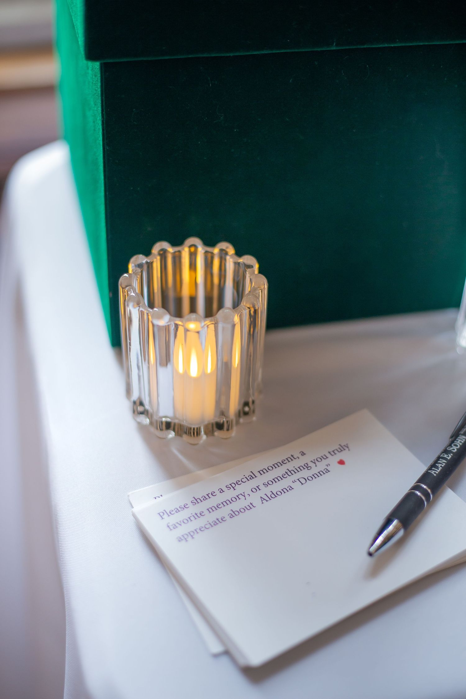 Crystal glass tealight holder casts warm glow on white paper with pen in sequence of progressive lighting shots.