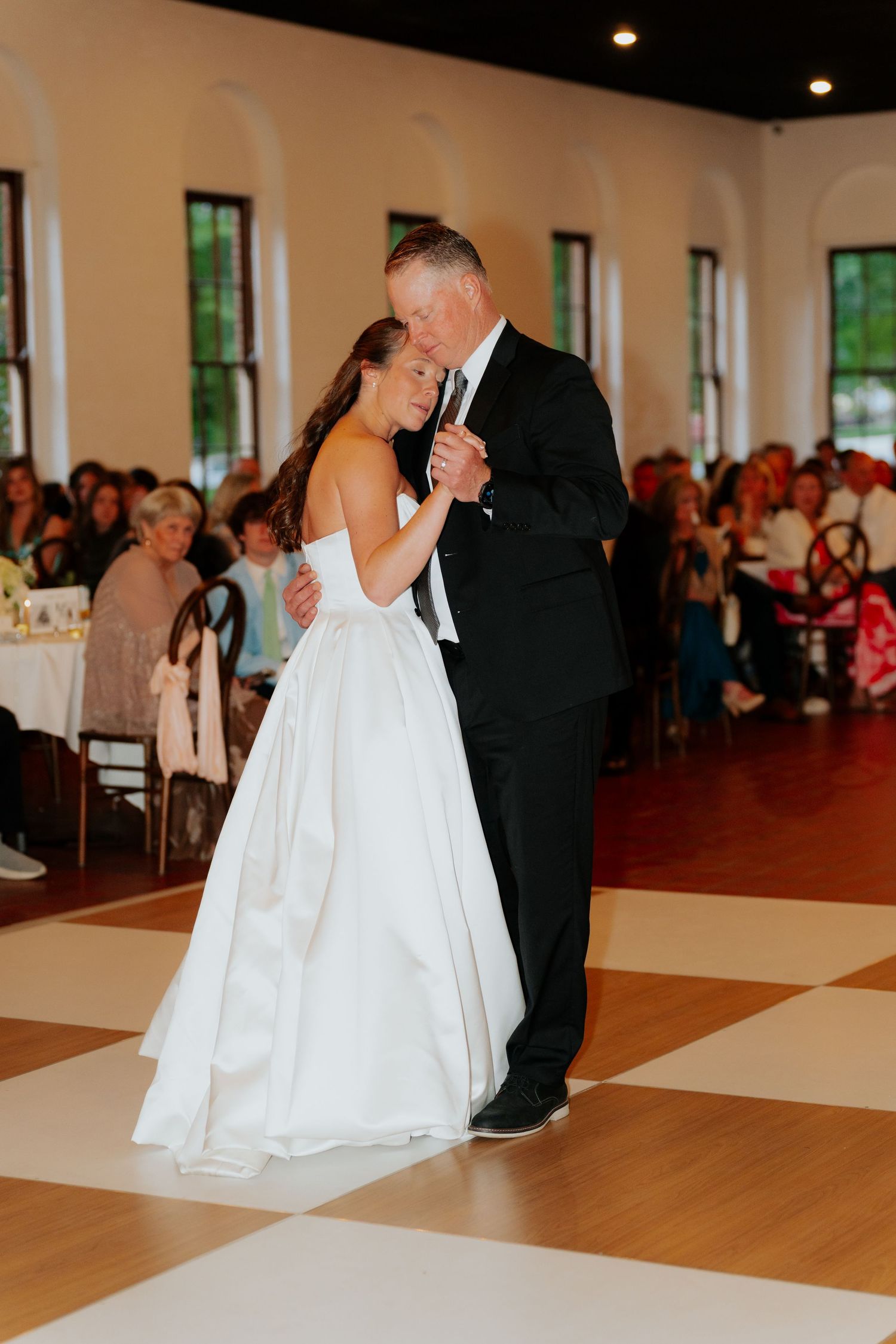 Bride shares an emotional father-daughter dance at a beautiful wedding reception.