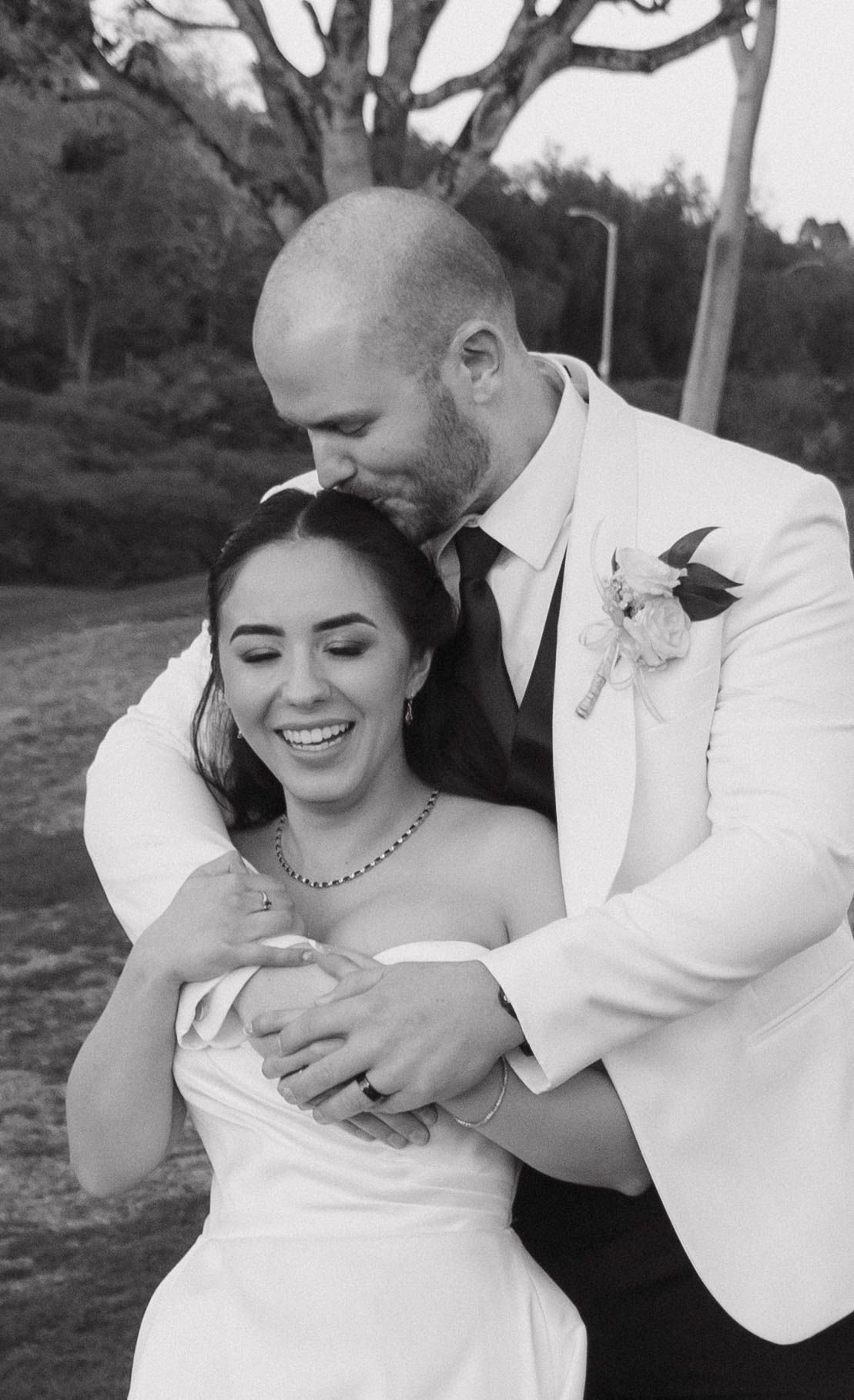A series of black and white wedding photos showing a couple embracing and laughing together outdoors.