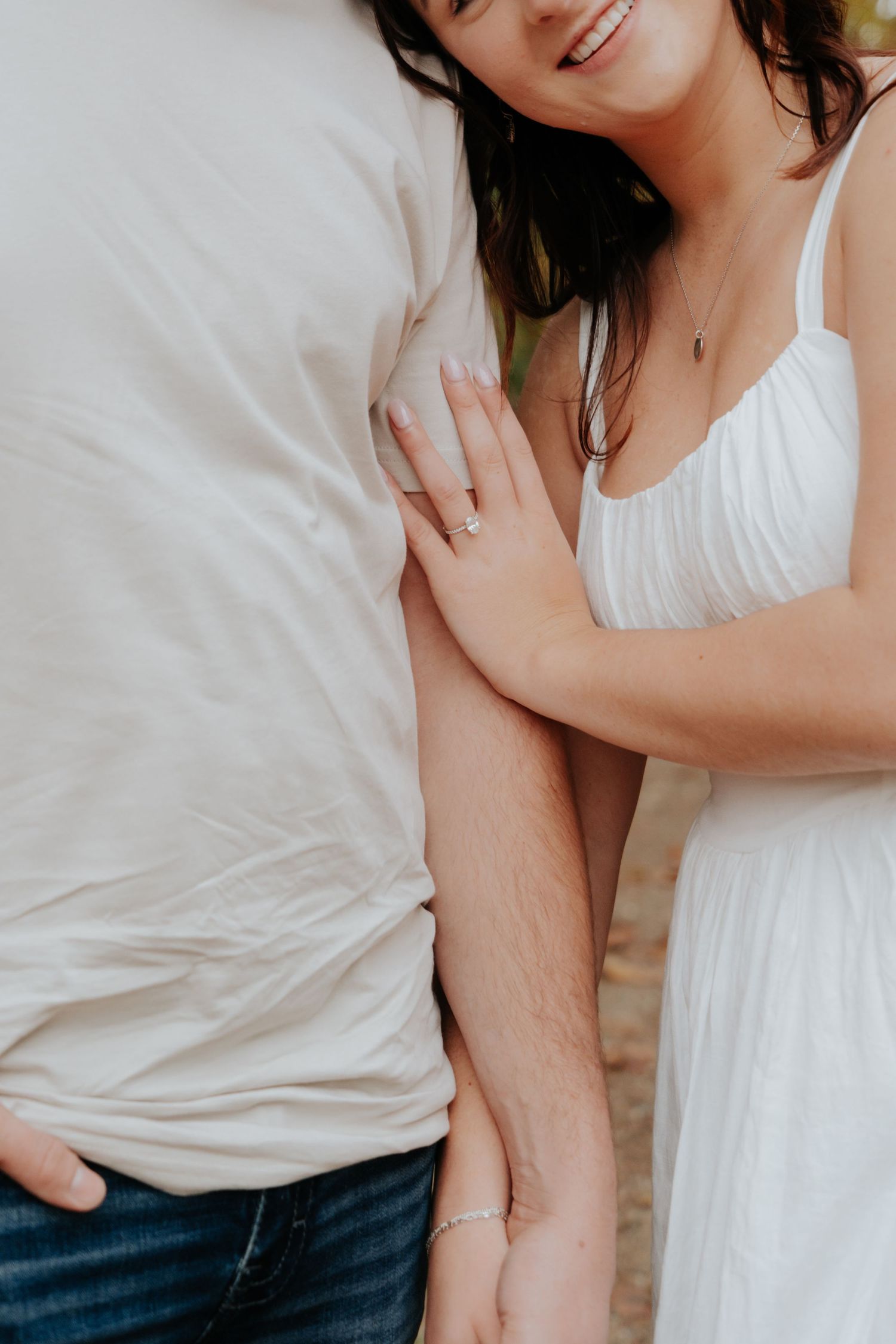 Intimate close-up shots of couple embracing in white clothing against neutral background.