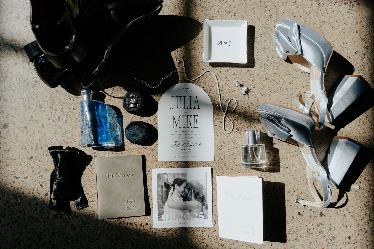 Flat lay of wedding photography accessories including shoes, invitations and decor on concrete surface.