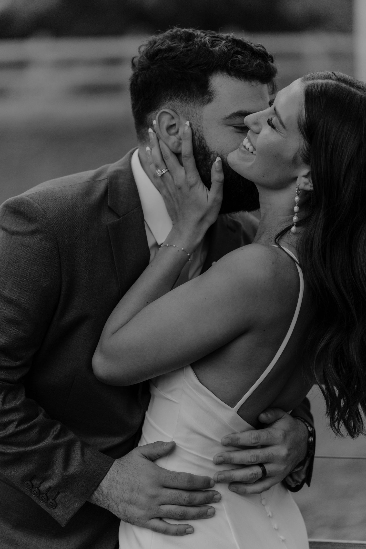 Black and white close-up of a bride and groom sharing a romantic kiss on their wedding day.