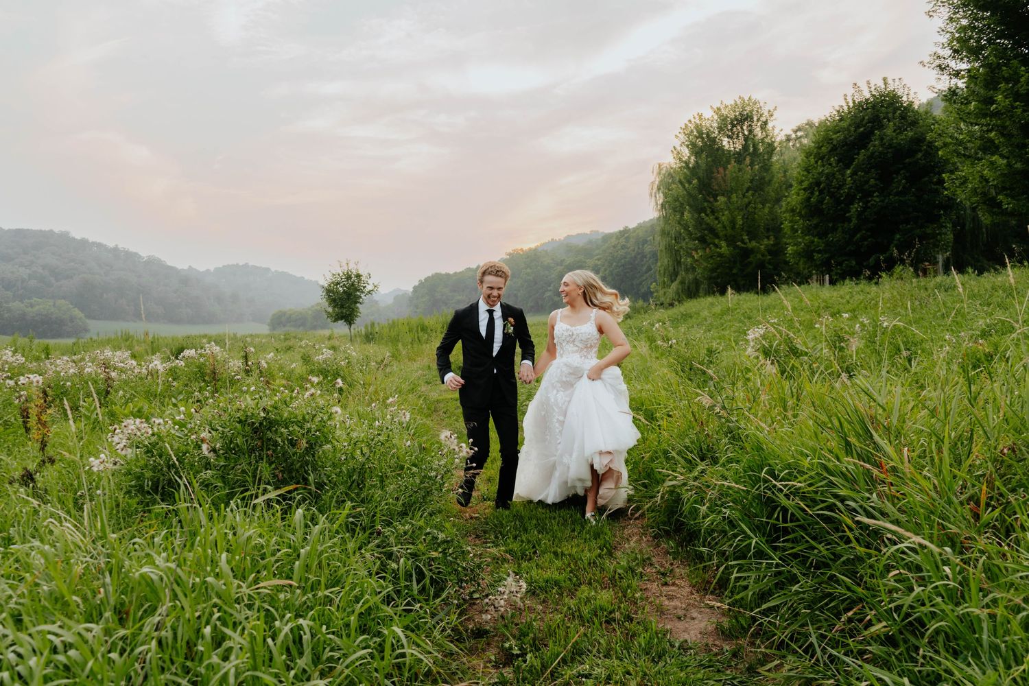 Panoramic view of a wedding couple in a scenic mountain meadow.