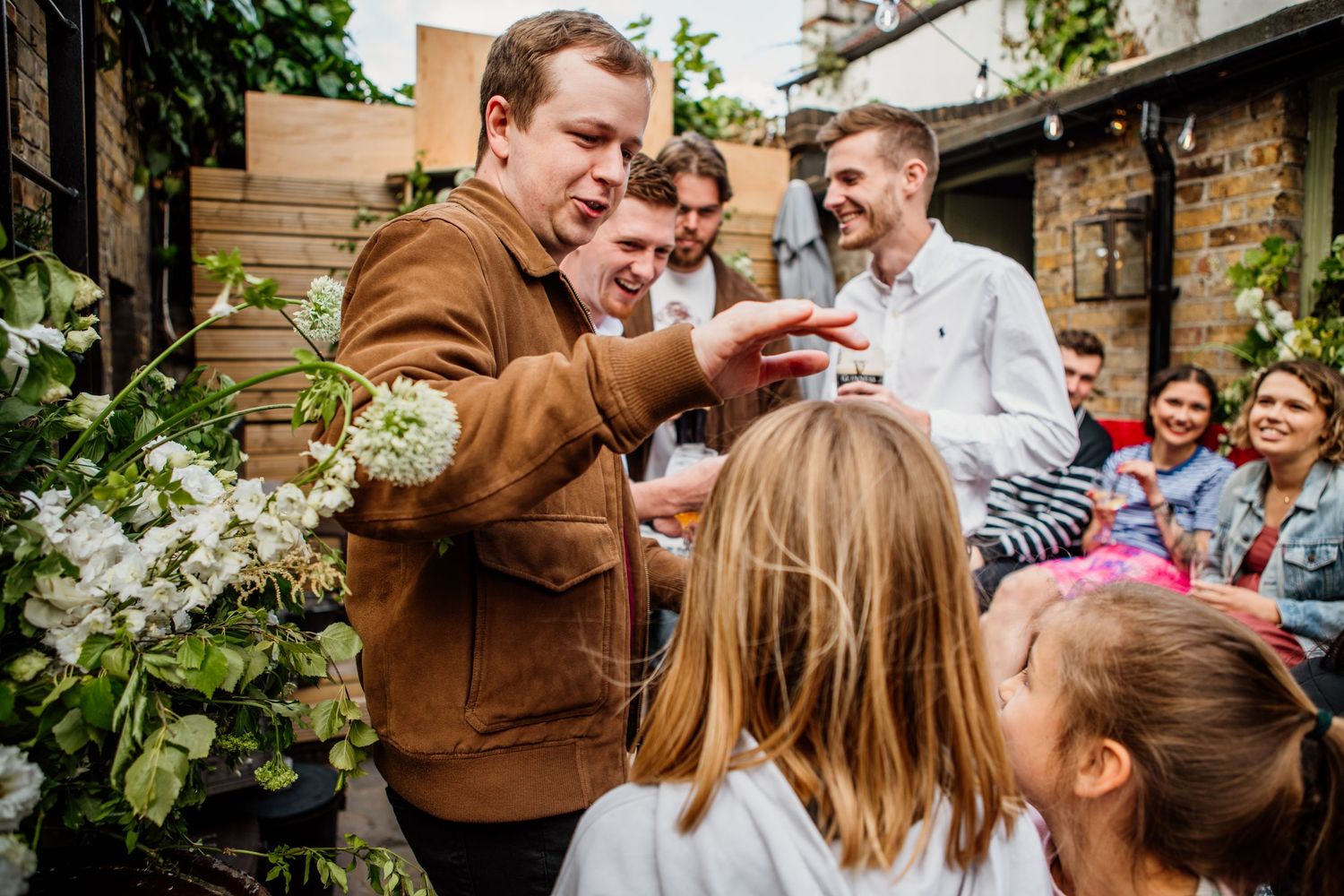 People sharing joyful moments at an outdoor garden party.