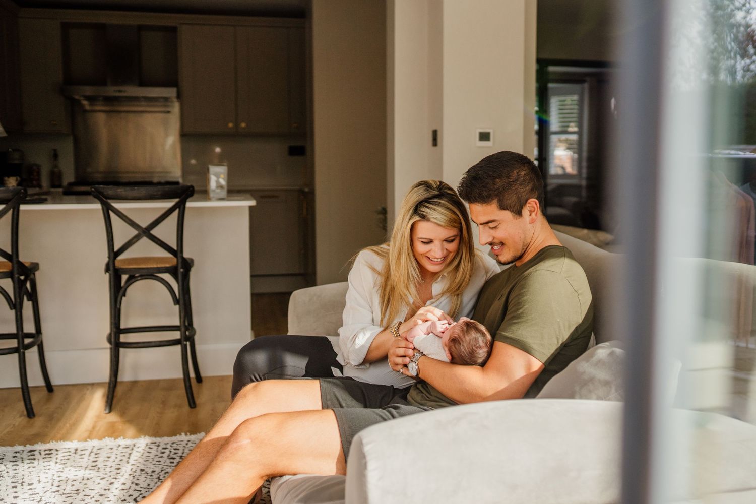Lifestyle newborn photography session showing tender family moments at home.