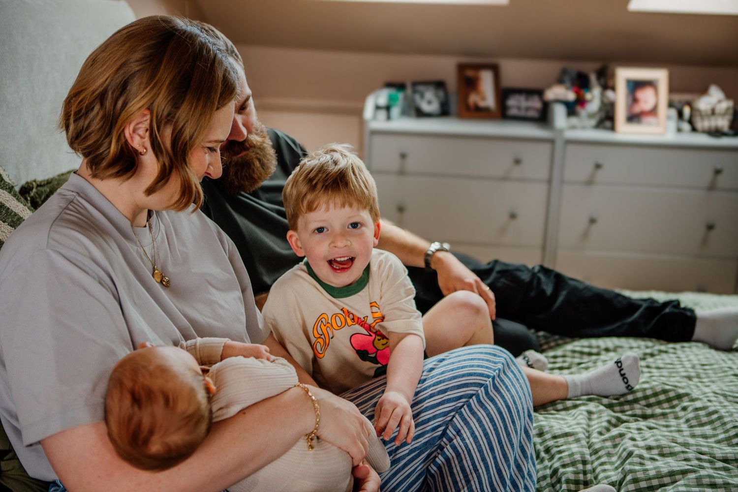 Candid lifestyle photos showing tender family moments on a cozy bed with natural lighting.