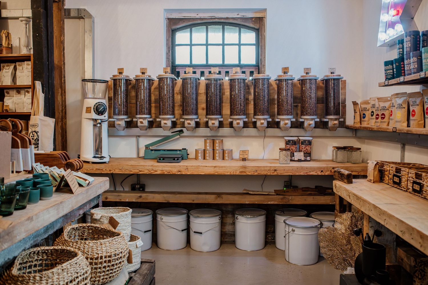 Interior view of a rustic pottery workshop with wooden shelves displaying ceramic vessels and pottery tools.